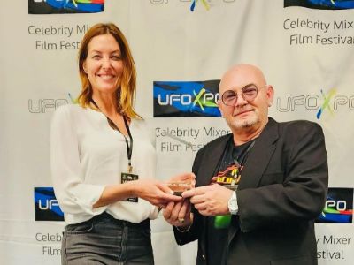 Melissa Tittl is holding the award while the other guy is giving it to her.